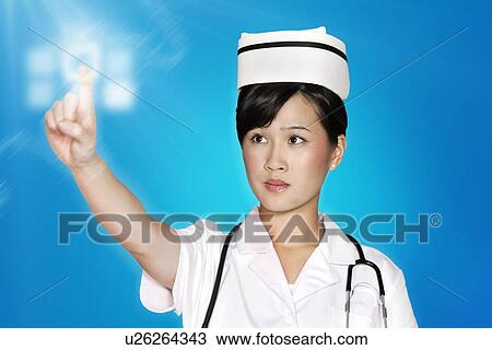 Stock Image - Female nurse using futuristic touch screen over blue background. Fotosearch