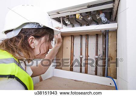 Female plumber examining pipes of central heating boiler View Large Photo Image Stock Image - Female plumber examining pipes of central heating boiler. Fotosearch