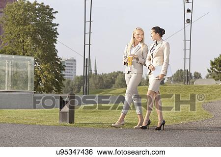 Full length of happy businesswomen walking together on street View Large Photo Image Stock Photograph - Full length of happy businesswomen walking together on street. Fotosearch