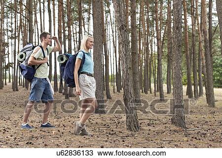 Full length of happy young couple trekking in forest View Large Photo Image Stock Image - Full length of happy young couple trekking in forest. Fotosearch