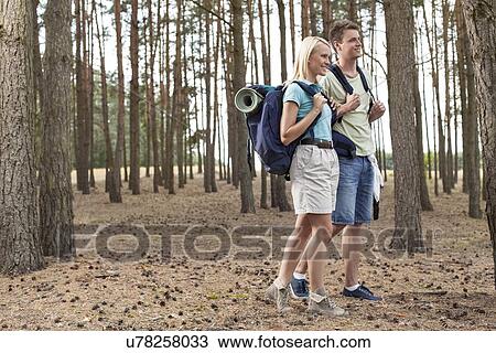 Full length of happy young couple hiking in forest View Large Photo Image Stock Image - Full length of happy young couple hiking in forest. Fotosearch