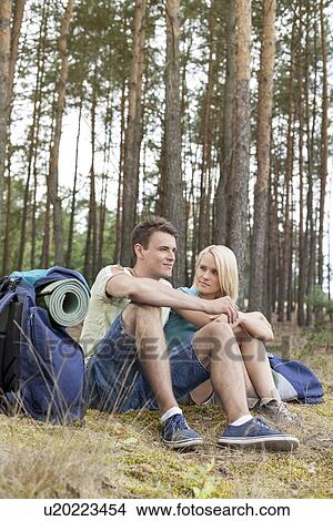 Full length of young backpacks relaxing in forest View Large Photo Image Picture - Full length of young backpacks relaxing in forest. Fotosearch