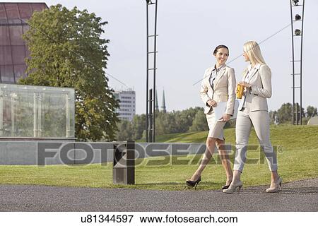 Full length of young businesswomen looking at each other while walking on street View Large Photo Image Stock Photo - Full length of young businesswomen looking at each other while walking on street. Fotosearch