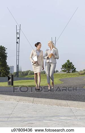 Full length of young businesswomen walking on street View Large Photo Image Stock Photograph - Full length of young businesswomen walking on street. Fotosearch