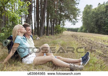 Full length of young hiking couple relaxing in forest View Large Photo Image Stock Photography - Full length of young hiking couple relaxing in forest. Fotosearch