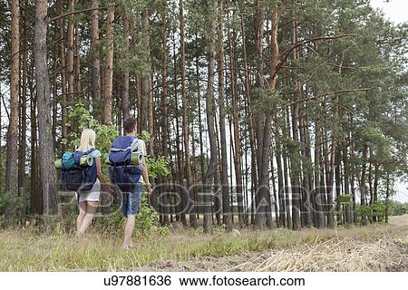 Full length rear view of young backpackers holding hands in woods View Large Photo Image Stock Photograph - Full length rear view of young backpackers holding hands in woods. Fotosearch