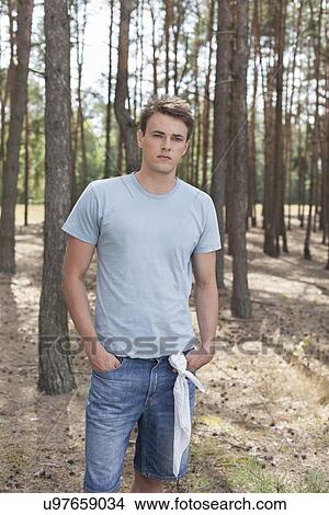 Picture - Handsome young man hiking in forest. Fotosearch