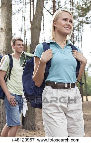 Happy young woman with man hiking in forest View Large Photo Image Stock Photo - Happy young woman with man hiking in forest. Fotosearch