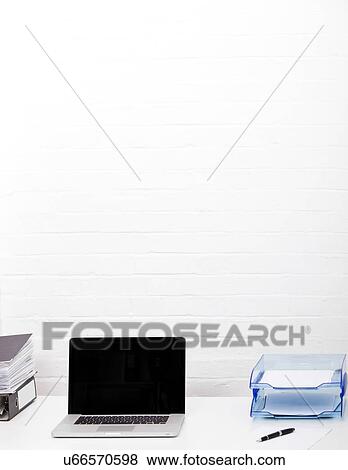 Stock Photo - Laptop and paper tray on office desk. Fotosearch