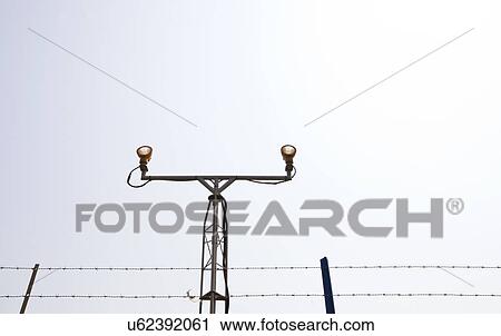 Lighting equipment at the start of airport runway surrounded by barb wire View Large Photo Image Stock Image - Lighting equipment at the start of airport runway surrounded by barb wire. Fotosearch