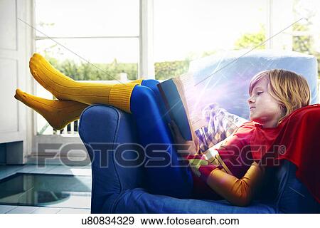 Little boy dressed as a super hero reading a book View Large Photo Image Stock Photo - Little boy dressed as a super hero reading a book. Fotosearch