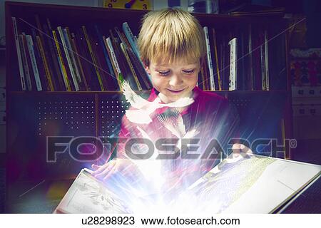 Stock Image - Little boy reading a book. Fotosearch