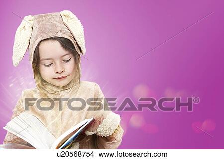 Picture - Little girl dressed as a bunny rabbit reading a book. Fotosearch