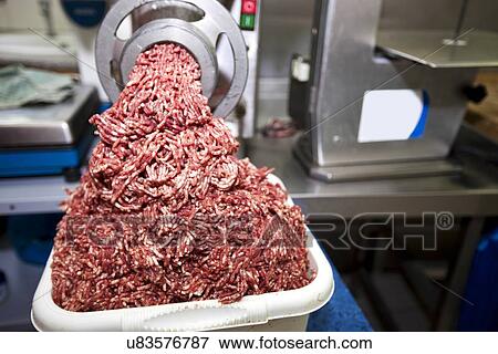 Machine mincing meat in grocery store View Large Photo Image Stock Photo - Machine mincing meat in grocery store. Fotosearch