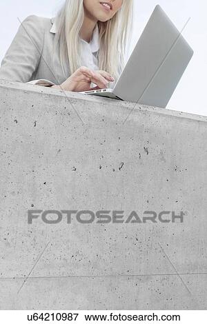 Mid section of young businesswoman using laptop on terrace View Large Photo Image Stock Photo - Mid section of young businesswoman using laptop on terrace. Fotosearch