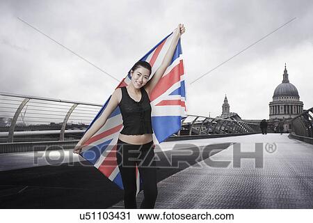 Stock Image - Olympic competitor with Union Jack in front of St Paul's Cathedral in London. Fotosearch