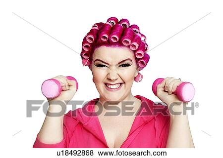 Stock Photo - Portrait of a young woman happily lifting weights. Fotosearch