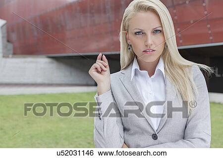 Portrait of confident businesswoman gesturing against office building View Large Photo Image Stock Photograph - Portrait of confident businesswoman gesturing against office building. Fotosearch