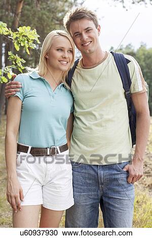 Portrait of happy man standing with woman while hiking in forest View Large Photo Image Stock Image - Portrait of happy man standing with woman while hiking in forest. Fotosearch