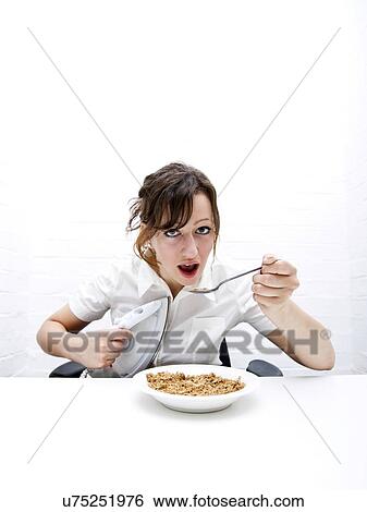 Portrait of young businesswoman ironing her shirt white having breakfast at table View Large Photo Image Stock Photograph - Portrait of young businesswoman ironing her shirt white having breakfast at table. Fotosearch
