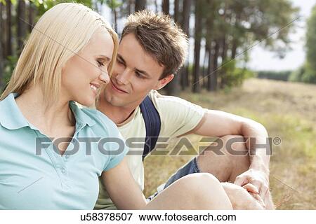 Romantic male hiker looking at woman while relaxing in forest View Large Photo Image Stock Photo - Romantic male hiker looking at woman while relaxing in forest. Fotosearch