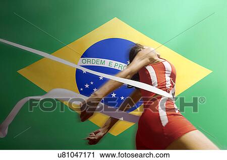 Runner Breaking through the finishing line tape over Brazilian flag View Large Photo Image Stock Image - Runner Breaking through the finishing line tape over Brazilian flag. Fotosearch