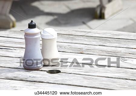 Stock Image - Salt and vinegar bottles on wooden table. Fotosearch
