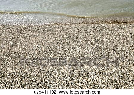 Stock Image - Sea and shingle beach. Fotosearch
