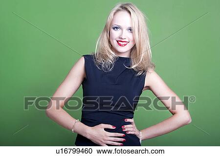 Stock Image - Sexy blonde businesswoman on green background. Fotosearch