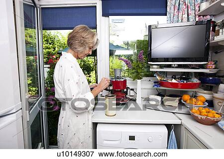 Side view of senior woman filling ground espresso in holder at kitchen View Large Photo Image Stock Photo - Side view of senior woman filling ground espresso in holder at kitchen. Fotosearch
