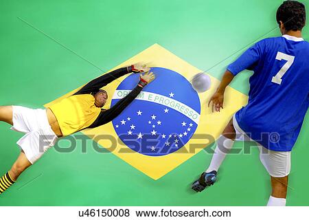 Stock Photo - Soccer player scoring goal in front of Brazilian Flag. Fotosearch