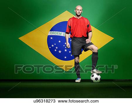 Soccer player standing in front of Brazilian flag View Large Photo Image Stock Image - Soccer player standing in front of Brazilian flag. Fotosearch
