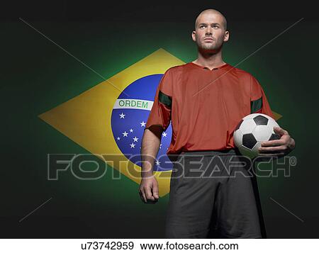 Stock Photo - Soccer player standing in front of Brazilian flag. Fotosearch
