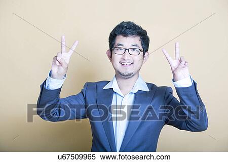 Stylish Asian man making 'peace' symbols View Large Photo Image Stock Photography - Stylish Asian man making 'peace' symbols. Fotosearch