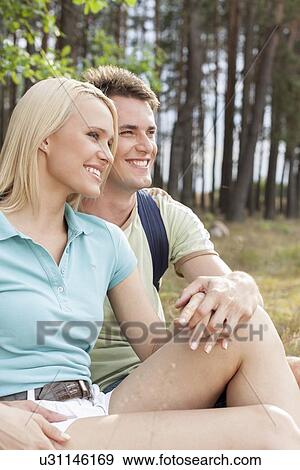 Thoughtful hiking couple looking away while relaxing in forest View Large Photo Image Stock Photo - Thoughtful hiking couple looking away while relaxing in forest. Fotosearch