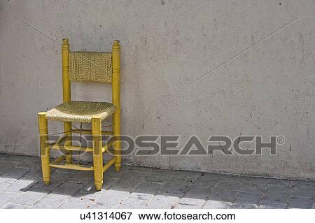 Stock Photo - Yellow Chair against Brick Wall in Istanbul. Fotosearch