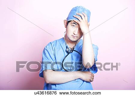 Young Asian surgeon wearing scrubs and looking stressed View Large Photo Image Stock Photograph - Young Asian surgeon wearing scrubs and looking stressed. Fotosearch