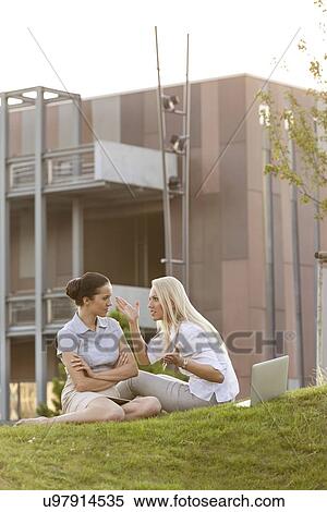 Stock Photography - Young businesswomen arguing on office lawn. Fotosearch