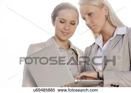 Young businesswomen using laptop against clear sky View Large Photo Image Stock Photography - Young businesswomen using laptop against clear sky. Fotosearch