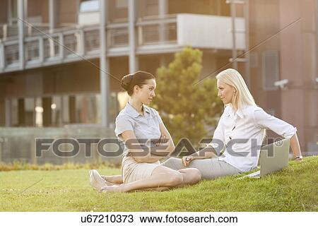 Young confident businesswomen looking at each other in office lawn View Large Photo Image Stock Image - Young confident businesswomen looking at each other in office lawn. Fotosearch
