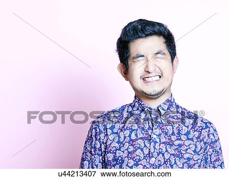 Young Geeky Asian Man in colorful shirt closing both eyes View Large Photo Image Stock Photo - Young Geeky Asian Man in colorful shirt closing both eyes. Fotosearch