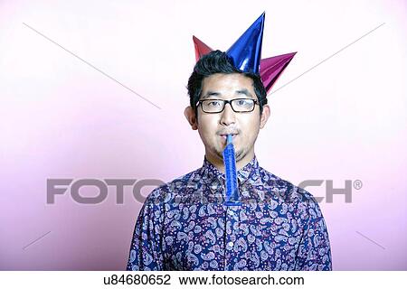 Young Geeky Asian Man wearing many party hats View Large Photo Image Stock Image - Young Geeky Asian Man wearing many party hats . Fotosearch