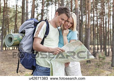 Young hiking couple reading map in forest View Large Photo Image Stock Image - Young hiking couple reading map in forest. Fotosearch