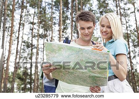 Young hiking couple reading map in forest View Large Photo Image Stock Photo - Young hiking couple reading map in forest. Fotosearch