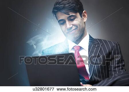 Stock Photo - Young Indian Business Man using illuminated tablet. Fotosearch