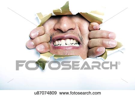 Stock Photo - Young Korean man looking through ripped paper hole. Fotosearch