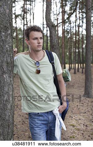 Young man with backpack hiking in woods View Large Photo Image Stock Image - Young man with backpack hiking in woods. Fotosearch