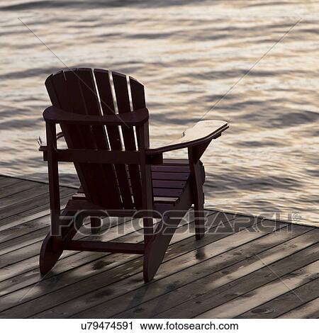 Adirondack chair on a dock at the Lake of The Woods, Ontario, Canada View Large Photo Image Stock Image - Adirondack chair on a dock at the Lake of The Woods, Ontario, Canada. Fotosearch