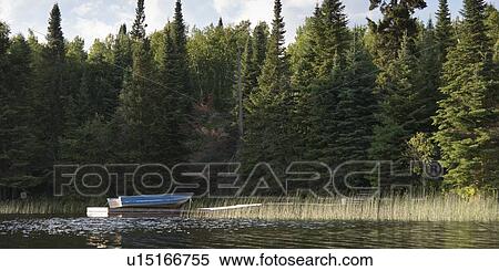 Stock Photography - Boat at a dock, Lake Of The Woods, Keewatin, Ontario, Canada. Fotosearch