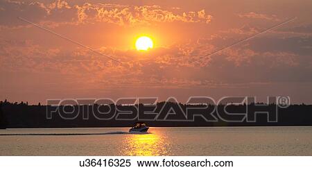 Boat in a lake at sunset, Lake Of The Woods, Keewatin, Ontario, Canada View Large Photo Image Stock Photography - Boat in a lake at sunset, Lake Of The Woods, Keewatin, Ontario, Canada. Fotosearch